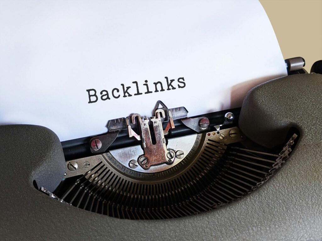Typewriter with blank page with the word "Backlinks" written. Bilingual SEO Checklist